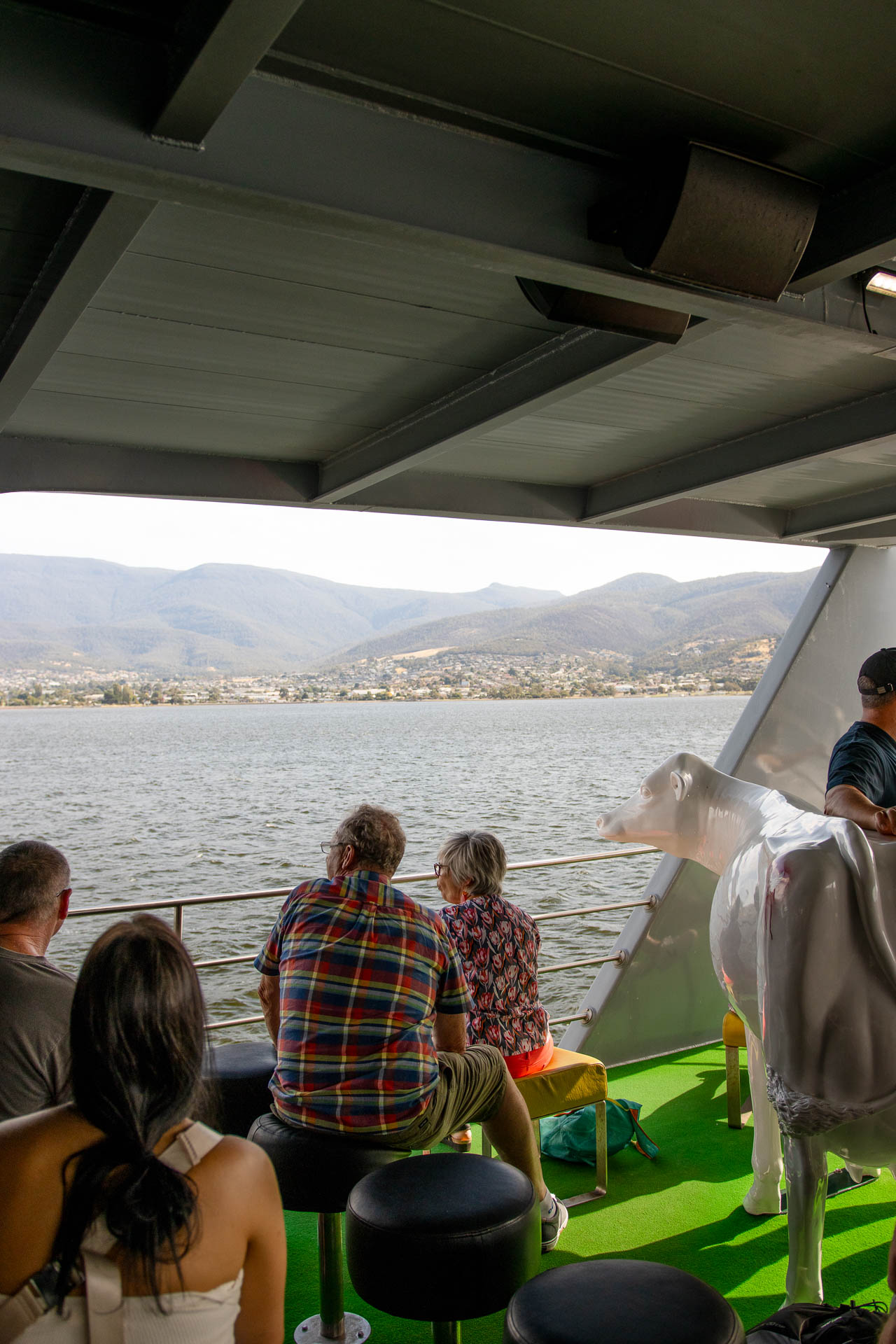 People sit on the MONA Ferry overlooking the Derwent River.